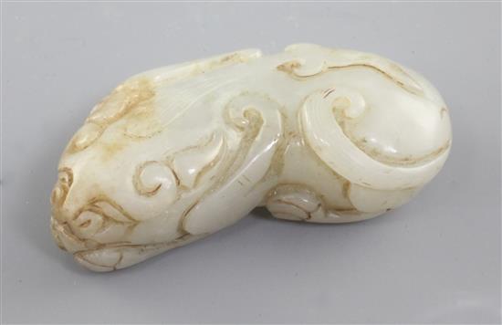 A Chinese pale celadon and russet jade figure of a recumbent beast, Qing dynasty, 5.1cm